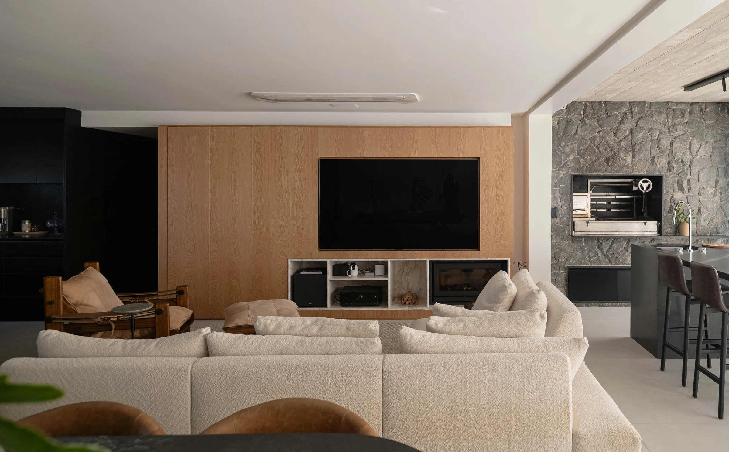 Modern entertainment center featuring a wall-mounted TV with organized media cabinet displaying AV receiver and subwoofer