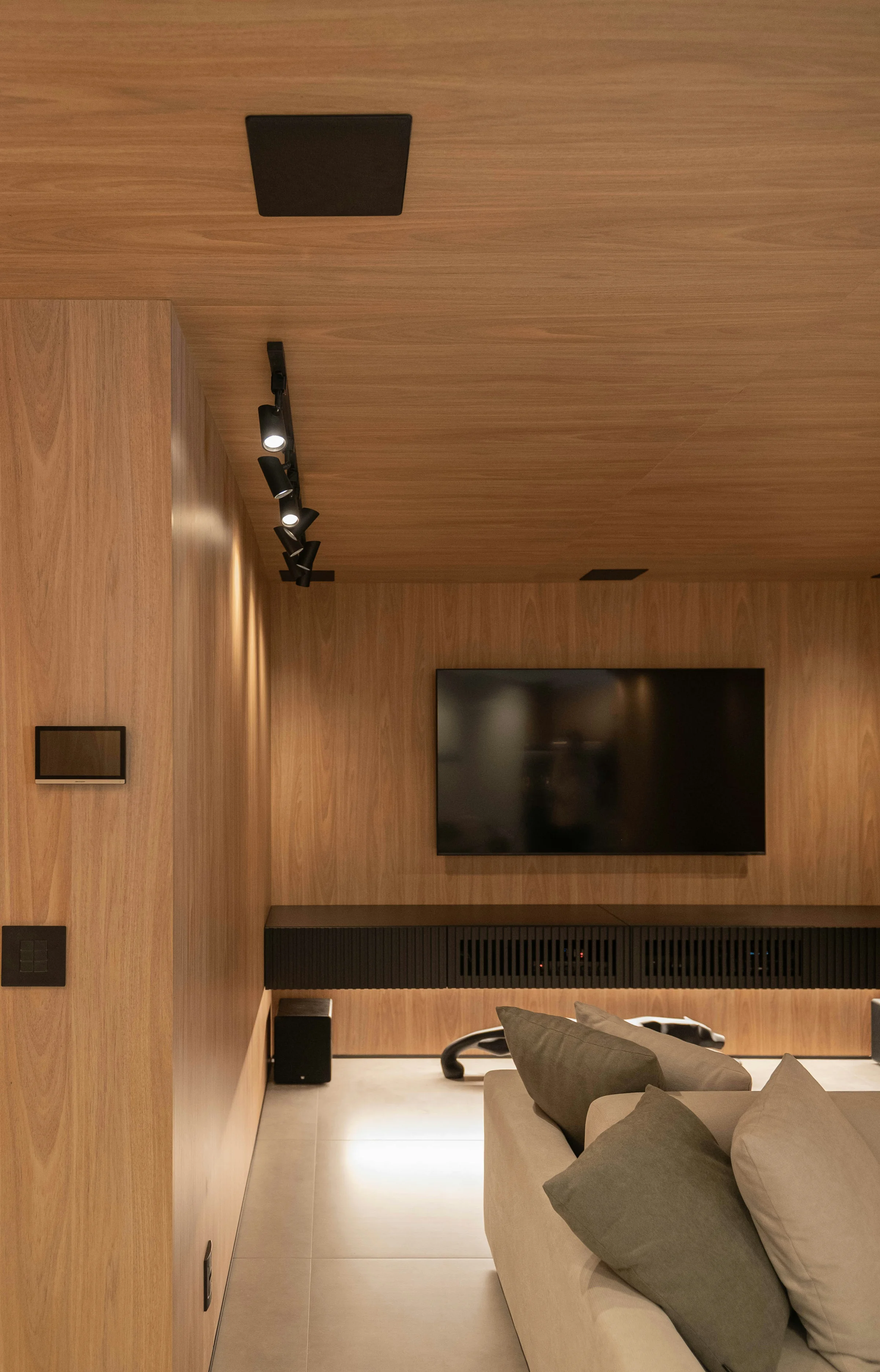 Modern entertainment center featuring a wall-mounted TV with organized media cabinet displaying AV receiver and subwoofer